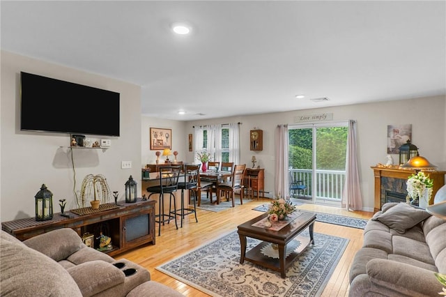 5 Leighas Ln, Coventry, RI 02816 - living room with light wood-style flooring, recessed lighting, a fireplace, and a baseboard radiator
