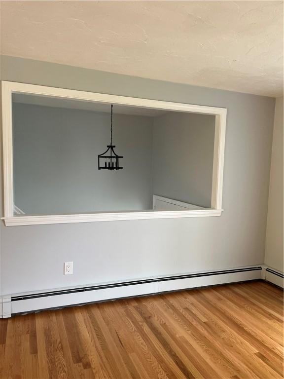 62 Lucille Dr, Woonsocket, RI 02895 - detailed view of a baseboard radiator and wood finished floors