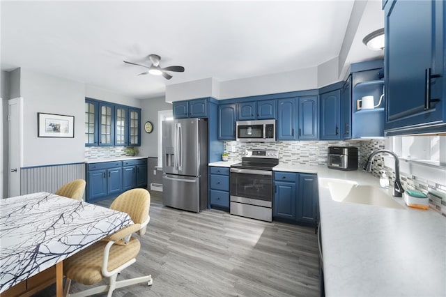 39 Camac St, Pawtucket, RI 02861 - kitchen featuring stainless steel appliances, a sink, blue cabinets, ceiling fan, and decorative backsplash