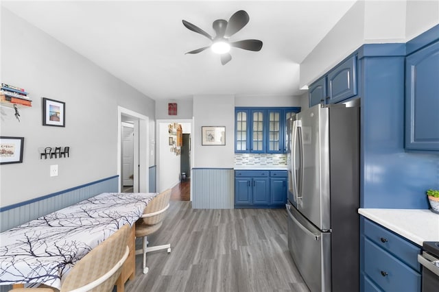39 Camac St, Pawtucket, RI 02861 - kitchen with freestanding refrigerator, blue cabinetry, ceiling fan, glass insert cabinets, and light countertops