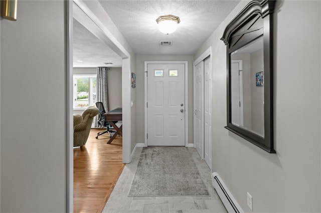 15 Womantam Ln, Cumberland, RI 02864 - entrance foyer featuring baseboards, a textured ceiling, and baseboard heating