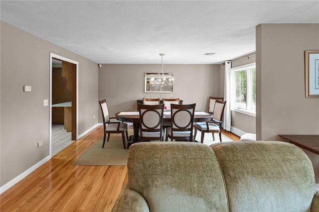 15 Womantam Ln, Cumberland, RI 02864 - dining space featuring light wood-style flooring, baseboards, and a chandelier