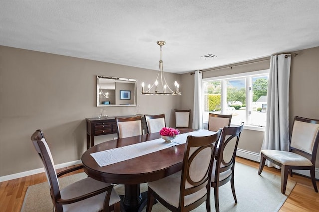 15 Womantam Ln, Cumberland, RI 02864 - dining space with light wood finished floors, a chandelier, baseboards, and baseboard heating
