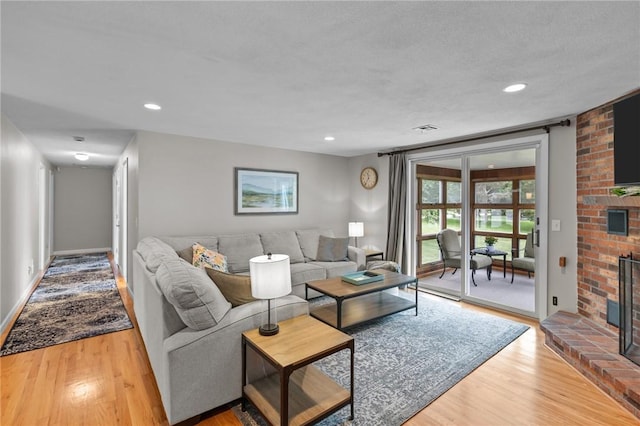 15 Womantam Ln, Cumberland, RI 02864 - living room with wood finished floors, a fireplace, recessed lighting, and baseboards