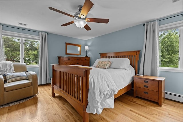 15 Womantam Ln, Cumberland, RI 02864 - bedroom featuring multiple windows, light wood finished floors, a baseboard heating unit, and a ceiling fan