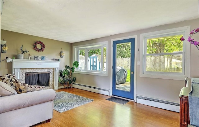 92 Chatworth Ave, Warwick, RI 02886 - living area with baseboard heating, wood finished floors, and a fireplace