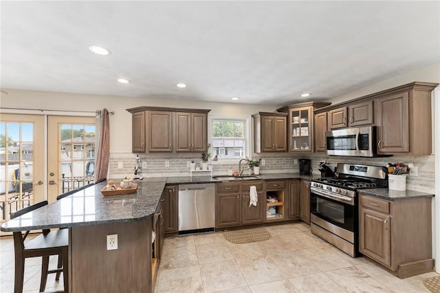 1710 Phenix Ave, Cranston, RI 02921 - kitchen with appliances with stainless steel finishes, a sink, a peninsula, decorative backsplash, and recessed lighting