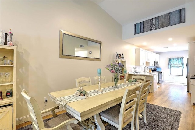 77 W Valley Cir Unit 77, West Warwick, RI 02893 - dining area featuring light wood-style floors, lofted ceiling, and baseboards