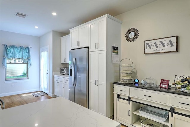 77 W Valley Cir Unit 77, West Warwick, RI 02893 - kitchen with stainless steel fridge with ice dispenser, white cabinetry, light stone counters, wood finished floors, and recessed lighting