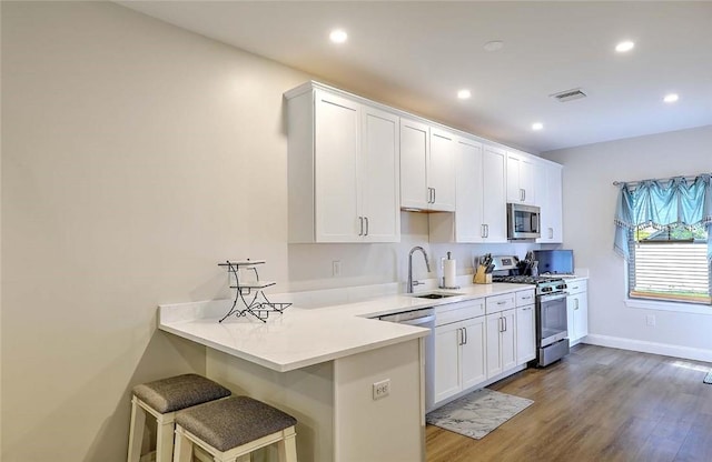 77 W Valley Cir Unit 77, West Warwick, RI 02893 - kitchen with appliances with stainless steel finishes, a sink, wood finished floors, white cabinets, and light countertops