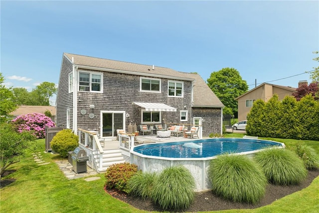 7 Maloney Ln, Middletown, RI 02842 - rear view of property featuring an outdoor hangout area, a lawn, an outdoor pool, and a deck