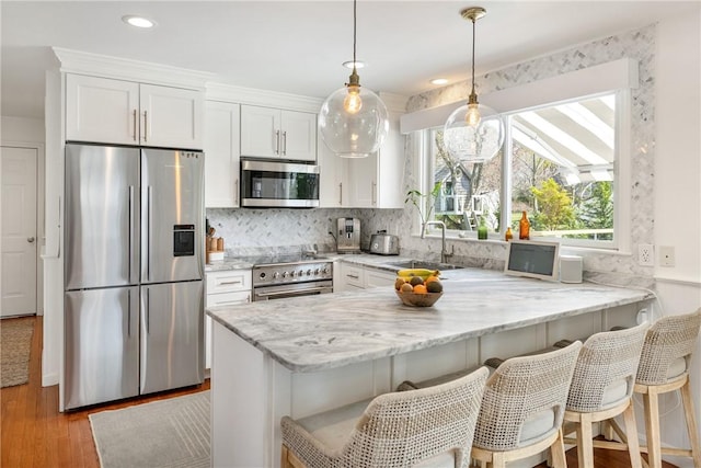 7 Maloney Ln, Middletown, RI 02842 - kitchen with appliances with stainless steel finishes, a sink, white cabinetry, a peninsula, and recessed lighting