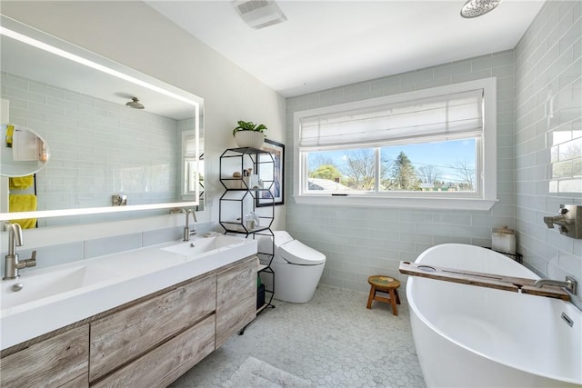 7 Maloney Ln, Middletown, RI 02842 - bathroom featuring tile walls, a freestanding bath, double vanity, and toilet
