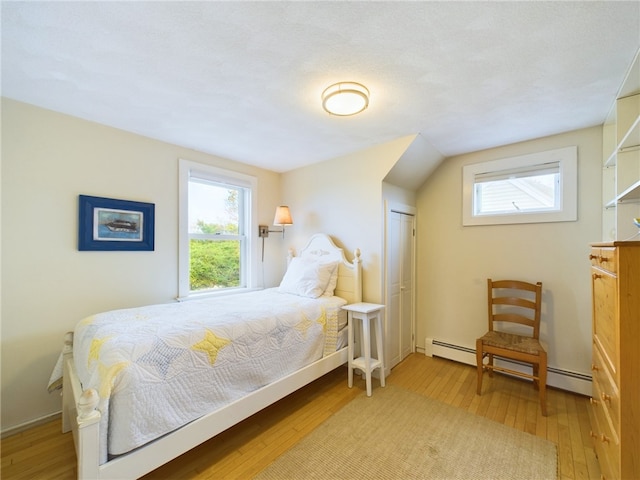 1087 Lakeside Dr, Block Island, RI 02807 - bedroom with a baseboard radiator, wood-type flooring, and multiple windows