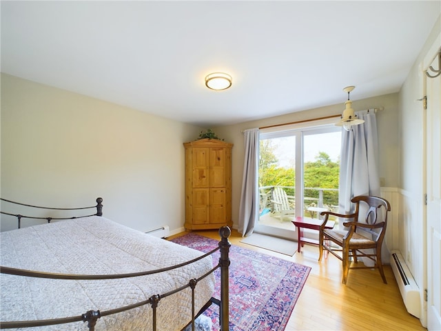 1087 Lakeside Dr, Block Island, RI 02807 - bedroom with baseboard heating, light wood-style floors, and access to outside