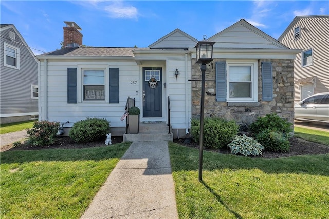257 Woodhaven Rd, Pawtucket, RI 02861 - view of front of house featuring a chimney, a front yard, and stone siding