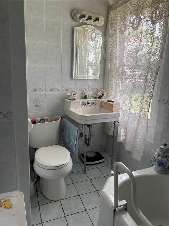 259 Park Ave, Woonsocket, RI 02895 - full bath featuring tile walls, a bathtub, toilet, and tile patterned floors