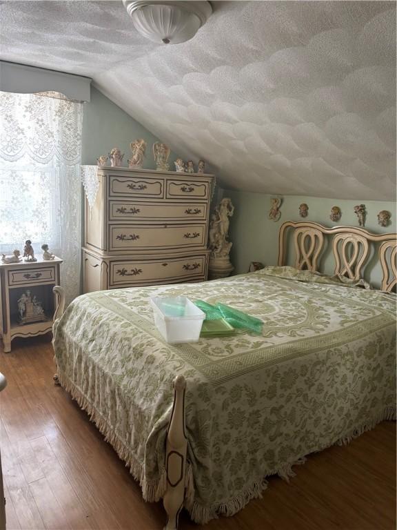 259 Park Ave, Woonsocket, RI 02895 - bedroom with a textured ceiling, vaulted ceiling, and wood finished floors