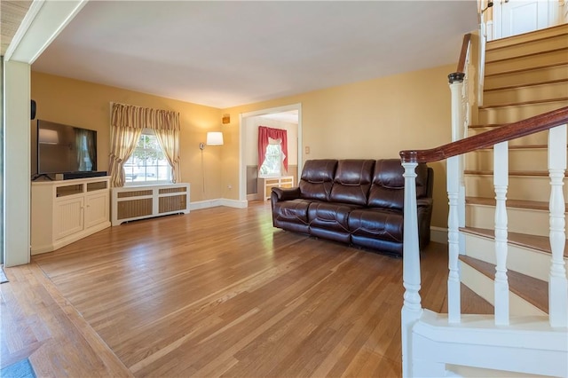 369 Vine St, Pawtucket, RI 02861 - living area featuring radiator heating unit, light wood-style floors, stairs, and baseboards