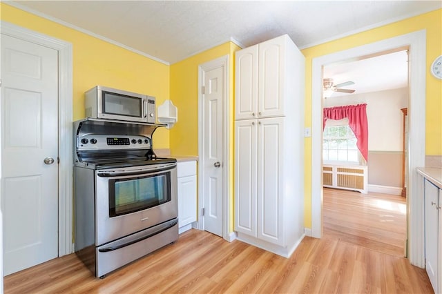 369 Vine St, Pawtucket, RI 02861 - kitchen featuring stainless steel appliances, light wood-style floors, white cabinetry, light countertops, and ornamental molding