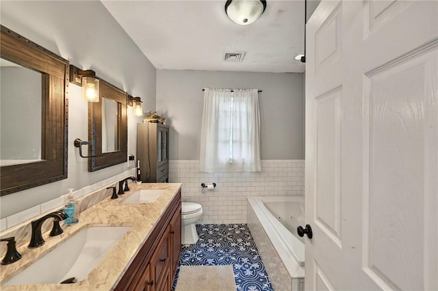 69 Arnold St, Lincoln, RI 02865 - bathroom featuring tile walls, tile patterned floors, toilet, double vanity, and a jetted tub