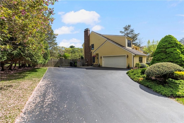 831 N Quidnessett Rd, North Kingstown, RI 02852 - view of property exterior featuring driveway, an attached garage, and a chimney