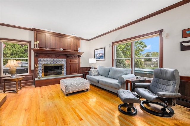 831 N Quidnessett Rd, North Kingstown, RI 02852 - living room featuring light wood-style flooring, ornamental molding, a wainscoted wall, and a fireplace