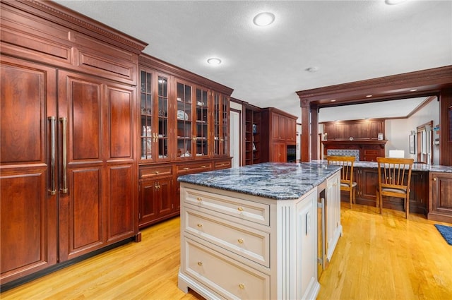 831 N Quidnessett Rd, North Kingstown, RI 02852 - kitchen featuring light wood finished floors, glass insert cabinets, dark stone countertops, and recessed lighting