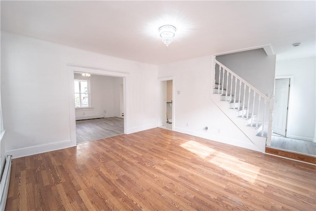 132 Chestnut St, Woonsocket, RI 02895 - unfurnished living room featuring stairway, wood finished floors, baseboard heating, and baseboards
