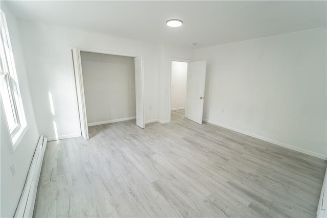 132 Chestnut St, Woonsocket, RI 02895 - unfurnished bedroom with a baseboard heating unit, light wood finished floors, and baseboards