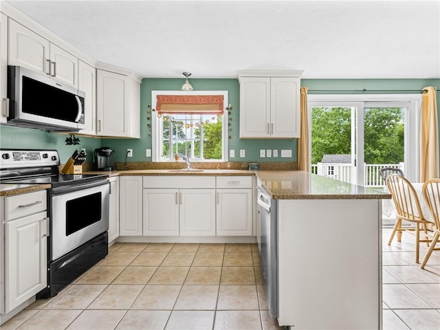 60 Broad St, Plainville, MA 02762 - kitchen with appliances with stainless steel finishes, a peninsula, light tile patterned floors, and white cabinets