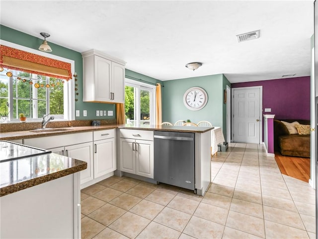 60 Broad St, Plainville, MA 02762 - kitchen featuring stainless steel dishwasher, a sink, light tile patterned floors, a peninsula, and white cabinets