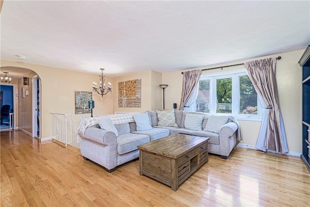 7 Lydia Ave, North Providence, RI 02904 - living area with a chandelier, arched walkways, light wood-style floors, and baseboards