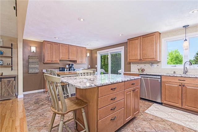 7 Lydia Ave, North Providence, RI 02904 - kitchen featuring stainless steel dishwasher, a sink, a kitchen bar, a center island, and light stone countertops
