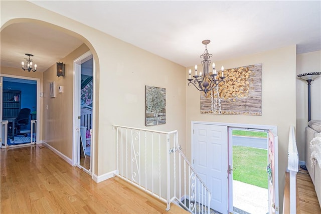 7 Lydia Ave, North Providence, RI 02904 - entryway with a chandelier, arched walkways, light wood-style flooring, and baseboards