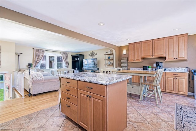 7 Lydia Ave, North Providence, RI 02904 - kitchen with a kitchen island, light stone counters, open floor plan, and recessed lighting