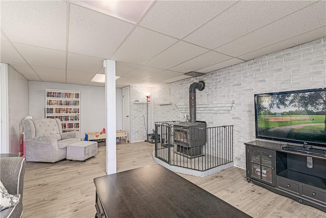 7 Lydia Ave, North Providence, RI 02904 - living area featuring wood finished floors, a drop ceiling, a wood stove, and brick wall
