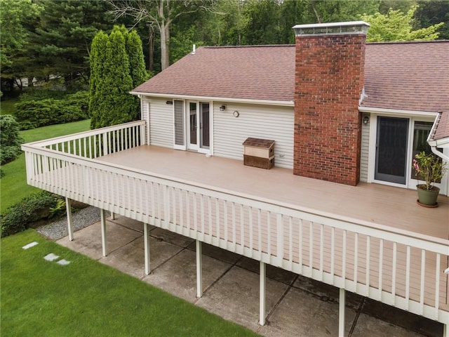 48 Nottingham Dr, Scituate, RI 02831 - rear view of property featuring a wooden deck, a chimney, roof with shingles, and a lawn