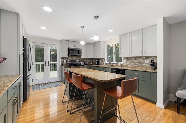 48 Nottingham Dr, Scituate, RI 02831 - kitchen with stainless steel appliances, a kitchen breakfast bar, backsplash, a kitchen island, and light wood-style floors