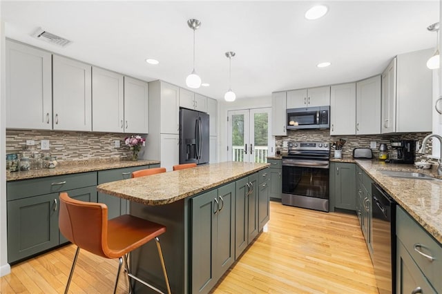48 Nottingham Dr, Scituate, RI 02831 - kitchen with appliances with stainless steel finishes, a sink, a kitchen island, light wood-type flooring, and recessed lighting