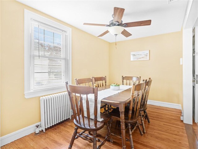 25 Community Rd, Warwick, RI 02889 - dining space with radiator heating unit, healthy amount of natural light, baseboards, and wood finished floors