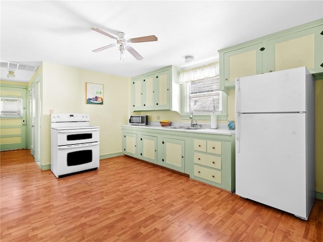 25 Community Rd, Warwick, RI 02889 - kitchen featuring white appliances, green cabinetry, a sink, and light wood-type flooring