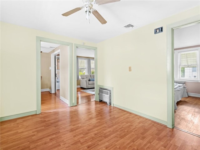 25 Community Rd, Warwick, RI 02889 - empty room featuring radiator heating unit, light wood finished floors, ceiling fan, and baseboards