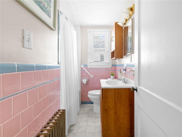 25 Community Rd, Warwick, RI 02889 - bathroom with vanity, radiator heating unit, toilet, tile walls, and wainscoting
