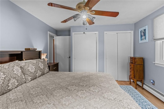 21 High Service Ave, North Providence, RI 02911 - bedroom with light wood-type flooring, two closets, a baseboard heating unit, and a ceiling fan