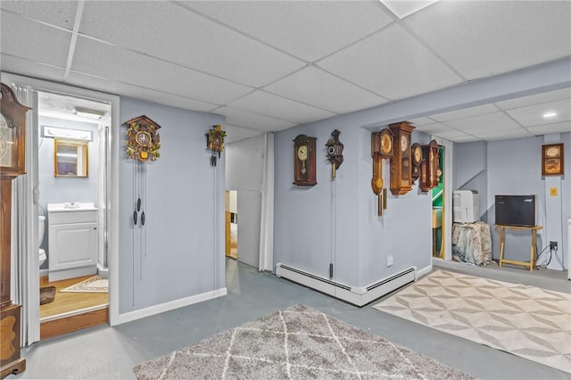 21 High Service Ave, North Providence, RI 02911 - finished below grade area with a paneled ceiling, a baseboard radiator, and baseboards