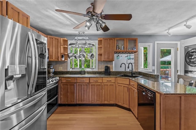 21 High Service Ave, North Providence, RI 02911 - kitchen with appliances with stainless steel finishes, a sink, open shelves, stacked washer / drying machine, and a peninsula