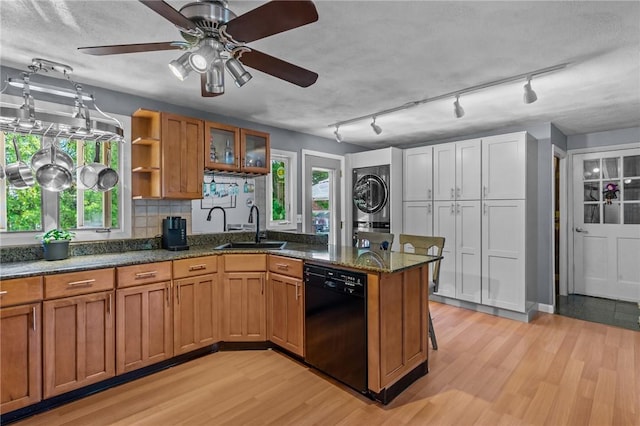 21 High Service Ave, North Providence, RI 02911 - kitchen with black dishwasher, stacked washer / drying machine, a sink, and brown cabinetry