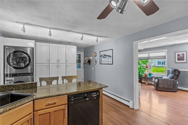 21 High Service Ave, North Providence, RI 02911 - kitchen with black dishwasher, stacked washing machine and dryer, a baseboard radiator, ceiling fan, and track lighting