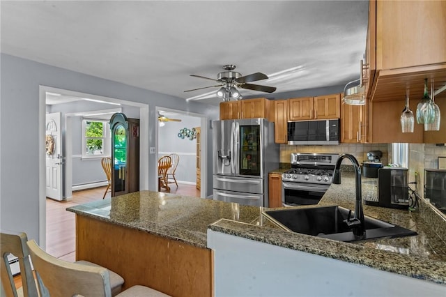 21 High Service Ave, North Providence, RI 02911 - kitchen featuring appliances with stainless steel finishes, a baseboard heating unit, a sink, and backsplash